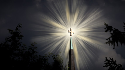goldenes Kreuz auf der Kirchturmspitze stahlt in der Dunkelheit