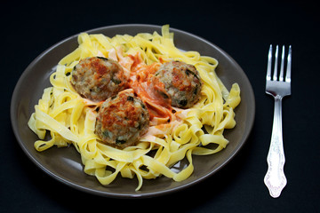 Pasta with meatballs on a dark background