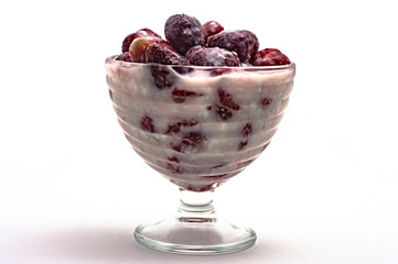 strawberries with yogurt in a glass vase on a white background close-up