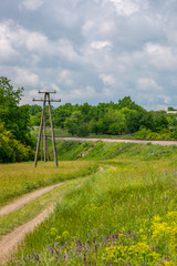 Fototapeta na wymiar Summer landscape with railway, country road and wildflowers