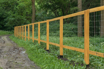 Wooden fence in the forest. Environmental protection concept.