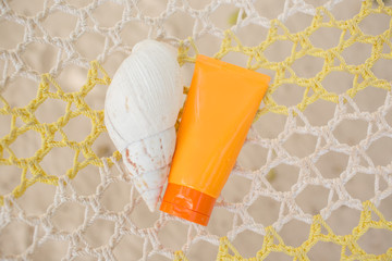 Jar of sunscreen and shell on the hammock. Skin protection concept.