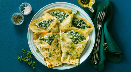 banner of Traditional Italian pancakes crepes with spinach and ricotta on a served blue table. healthy vegetarian diet