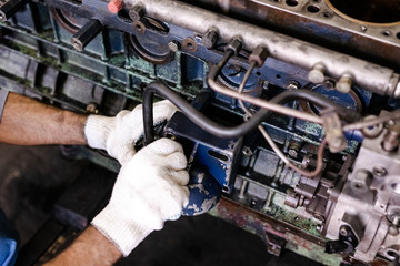 Mechanic opened the locking valve mechanism. Disassemble engine block vehicle. Old motor capital repair. Car service concept