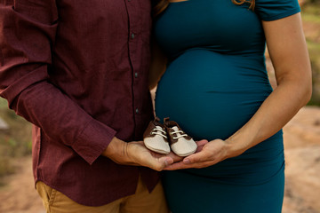 Maternity Belly Couple with baby shoes 