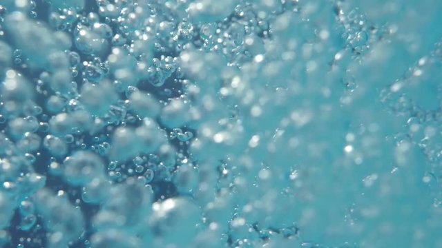 Bubbles rising to the surface. Slow motion. Air bubbles in clear blue water (underwater shot), good for backgrounds