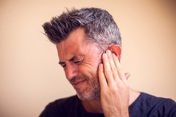 Man feels ear pain isolated. People, healthcare and medicine concept