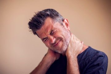 Fototapeta premium Man feels neck pain isolated. People, healthcare and medicine concept