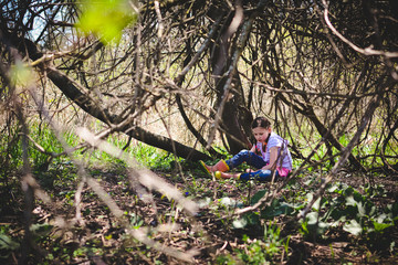 Naklejka na ściany i meble Girl Wearing Pink Rubber Boots Playing Under a Tree in the Spring
