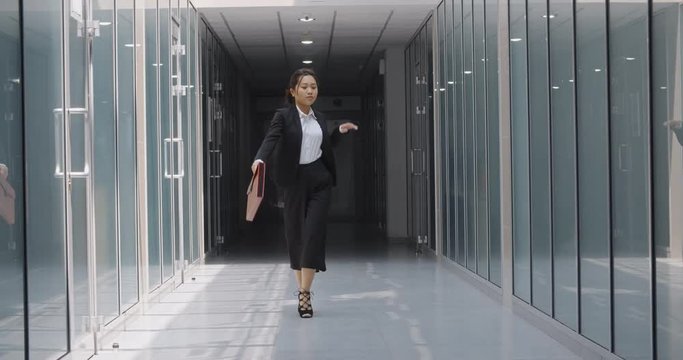 Funny asian businesswoman dancing in office hall, celebrating her achievement. Successful manager doing victory dance - way to success concept 4k