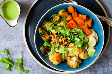 Salad of warm roasted vegetables, cauliflower, brussel sprouts, butternut squash and beans with green dressing