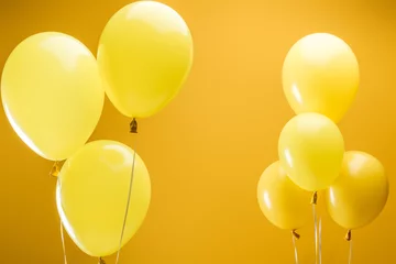 Deurstickers festive bright minimalistic balloons on yellow background © LIGHTFIELD STUDIOS