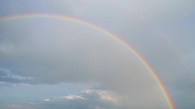 Vertical panorama. Rural landscape, rain clouds and rainbow
