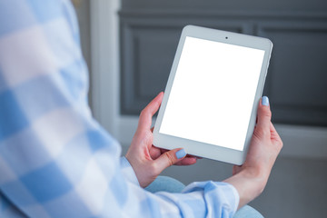 Over shoulder closeup view: woman hands holding digital tablet computer device with white blank...