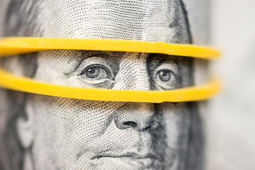 Benjamin Franklin's look on a hundred dollar bill highlighted with gum