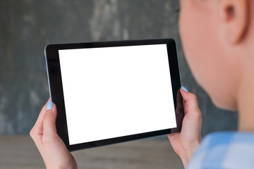 Mockup image - woman hands holding digital tablet computer device with white blank screen in empty living room. Mock up, entertainment, copyspace, template, leisure time and technology concept 