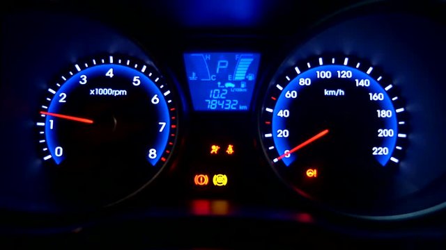 Car console illuminating blue on ignition. Static close up.