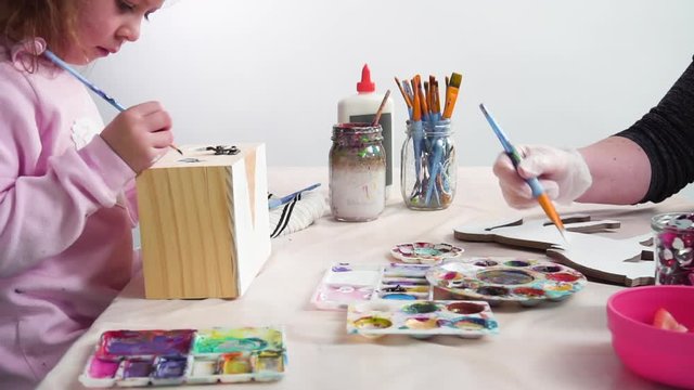 Painting with a white acrylic paint unicorn paper mache figurine.