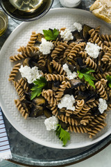 gluten-free pasta from half-wheat farro flour with portobello mushrooms and ricotta cheese on a tray on a marble table. healthy vegetarian recipes