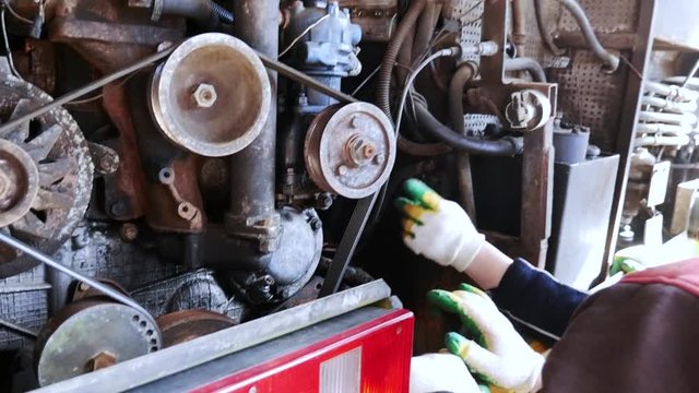 Mechanic working on diesel engine repair shop.