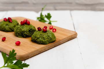 Spinach balls called Pkhali, traditional Georgian cuisine, on white wooden background.  Image with copy space, selective focus.
