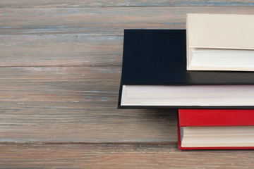 Multi-colored books on wooden table. Back to school. Copy space for text. Education business concept.