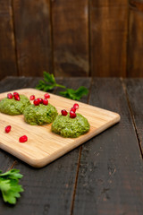 Spinach balls called Pkhali, traditional Georgian cuisine, on wooden background.  Image with copy space, selective focus.