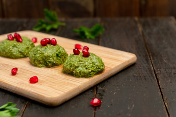 Spinach balls called Pkhali, traditional Georgian cuisine, on wooden background.  Image with copy space, selective focus.