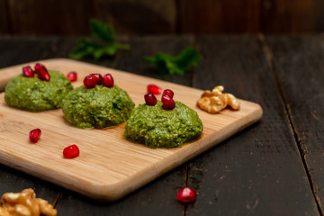 Spinach balls called Pkhali, traditional Georgian cuisine, on wooden background.  Image with copy space, selective focus.