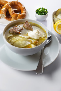 Soup Rassolnik with pickled cucumber and sour cream on a white background. Russian cuisine. Close up. Selective focus. For the menu.