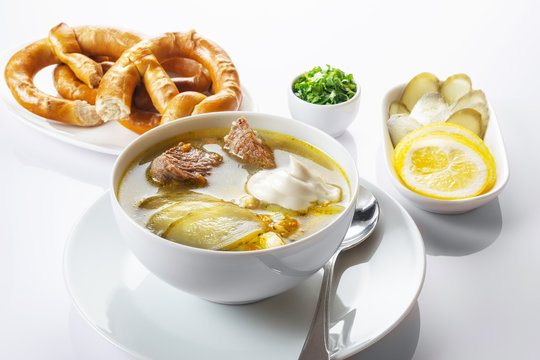 Soup Rassolnik with pickled cucumber and sour cream on a white background. Russian cuisine. Close up. Selective focus. For the menu.