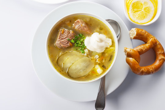 Soup Rassolnik with pickled cucumber and sour cream on a white background. Russian cuisine. Close up. Selective focus. For the menu.