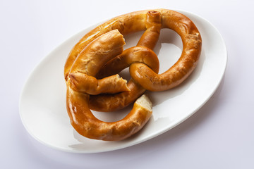 Pretzel on a white plate. Close up. Selective focus.