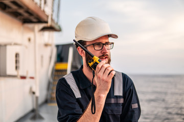 Deck Officer on deck of offshore vessel or ship , wearing PPE personal protective equipment. He...