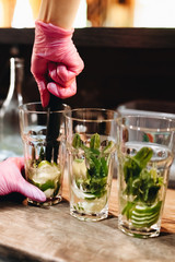 Barman making Mojito cocktail in pub