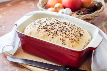 Homemade wheat bread with flax seeds in ceramic baking dish