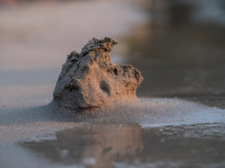 Sand castle/sculpture washing in to the sea as waves slowly eats from it - pictures at sunset on a caribbean beach