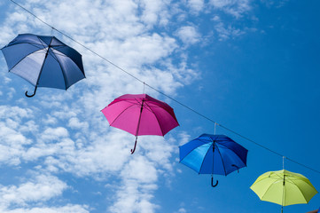 Fototapeta na wymiar Hanging umbrellas in a street of a small town close to Garda lake, Italy