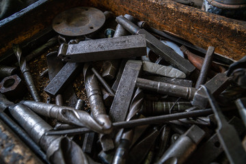 Bunch of old tools in a wooden box on a workshop shelf