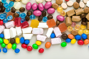 multicolored caramel candies scattered on the table background. sugar products. colored sweets