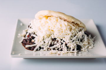 Delicious arepa stuffed with black beans and grated white cheese