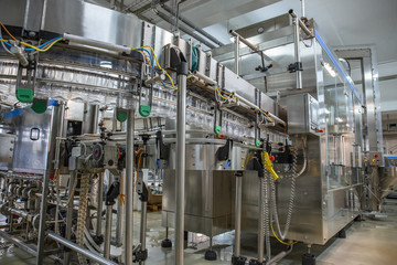 Automatic machine for molding, making shape and filling empty plastic bottles with drink. Conveyor line manufacturing. Juice and water plant or factory