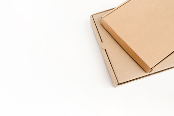 Two flat cardboard packages for goods lie on each other, isolated on a white background. Recyclable eco-friendly material.