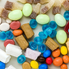multicolored caramel candies scattered on the table background. sugar products. colored sweets