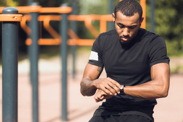 Fototapeta na wymiar Sporty Man Checking His Performance On Fitness Smartwatch