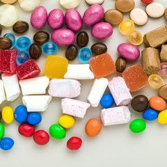 multicolored caramel candies scattered on the table background. sugar products. colored sweets
