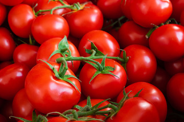 Many red tomatoes on the market. Closeup food background.