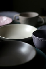 Collection of pottery and kitchenware in muted pastel colors. Selective focus.