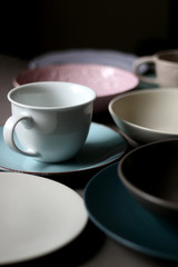 Collection of pottery and kitchenware in muted pastel colors. Selective focus.