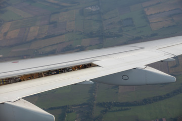 In-flight view on aircraft wing with spoilers deployed during approach